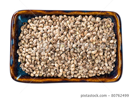 top view of unpeeled hemp seeds in bowl cutout 80762499