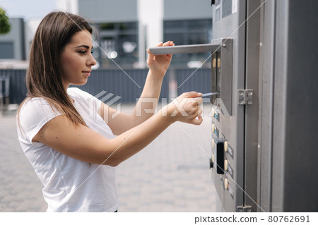 Woman put plactic card for paying outdoors on self-service car wash Woman put plactic card for paying outdoors on self-service car wash 80762691