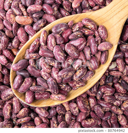 red spotted pinto beans in wooden spoon closeup 80764942