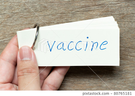 Man hold the flash card with handwriting word vaccine on wood background 80765181