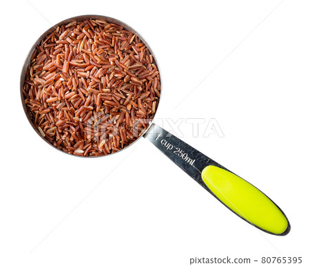 raw red rice in measuring cup cutout on white 80765395
