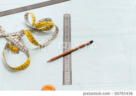 measure tape, rulers and pencil on pattern layout 80765436