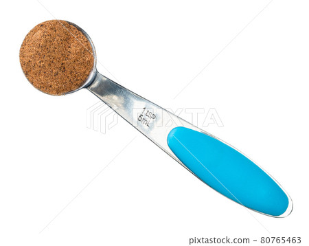 nutmeg powder in measuring teaspoon cutout 80765463