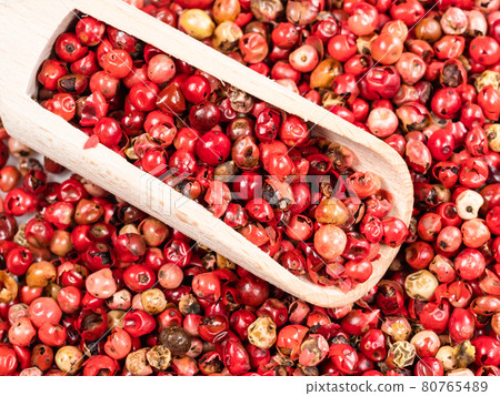 scoop on pile of pink peppercorns closeup 80765489
