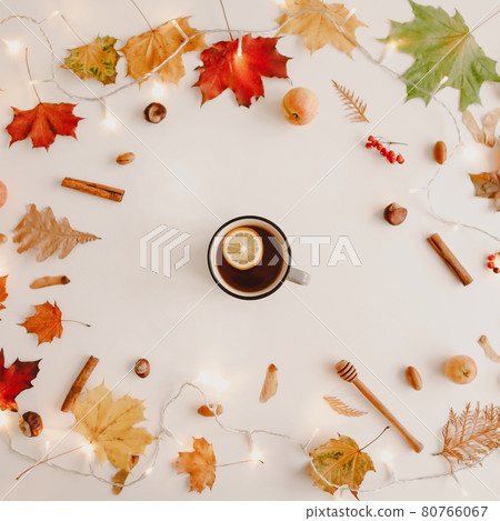 cup of lemon tea in frame of orange and red leaves. Creative autumn pattern, postcard. copy space, top view. 80766067
