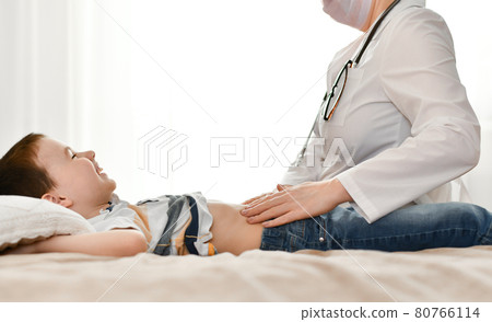 A happy child laughs during an examination of the abdominal wall by a doctor. A happy child laughs during an examination of the abdominal wall by a doctor. 80766114