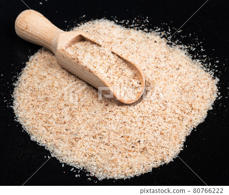 wooden scoop in Psyllium husk on black plate wooden scoop in Psyllium husk on black plate 80766222