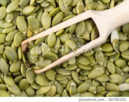 top view of wooden scoop on peeled pumpkin seeds top view of wooden scoop on peeled pumpkin seeds 80766330