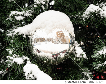 snow-covered mirrored ball on Christmas tree snow-covered mirrored ball on Christmas tree 80766475