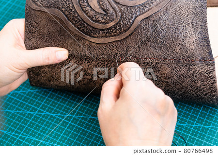craftsman sews the flap to the leather handbag craftsman sews the flap to the leather handbag 80766498