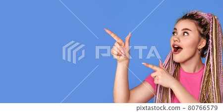 smiling blonde woman pointing away smiling blonde woman pointing away 80766579