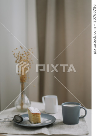 Morning breakfast with a piece of fresh homemade cake with a cup of cappuccino on a table with linen tablecloth.  80766786