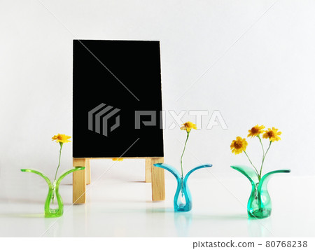 複製夾在塑料夾之間的黃色花朵和黑色招牌的空間 80768238