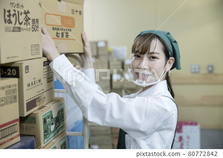 一名女僱員，在一家超市的後院裡用口罩工作 80772842