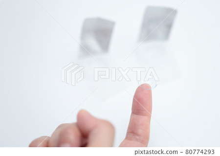Female fingers wearing contact lenses 80774293