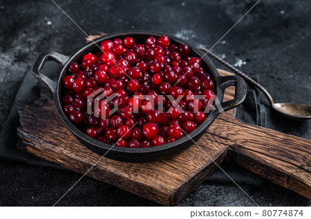 Red fresh Cranberry berry in a pan. Black background. Top view Red fresh Cranberry berry in a pan. Black background. Top view 80774874