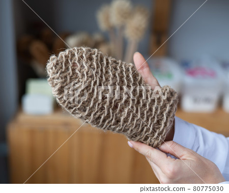 Woman holding eco body sponge in the shape of a mitten. Natural products with zero waste 80775030