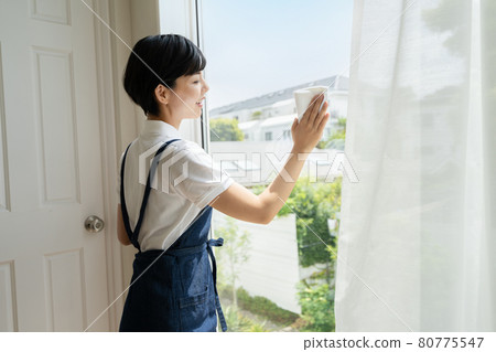 年輕女子清潔窗戶 年輕女子清潔窗戶 80775547