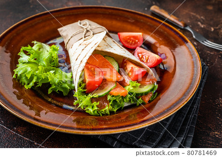 Wrap roll sandwich with fish salmon and vegetables. Dark background. Top view Wrap roll sandwich with fish salmon and vegetables. Dark background. Top view 80781469