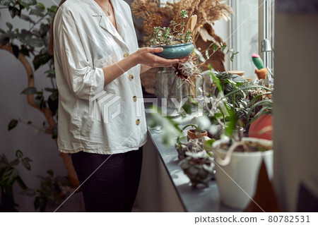 caucasian confident happy florist is working with composition made from glass stones and plants in botanic shop caucasian confident happy florist is working with composition made from glass stones and plants in botanic shop 80782531