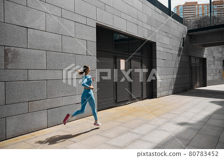 Beautiful fit young woman jogger is running outdoors Beautiful fit young woman jogger is running outdoors 80783452