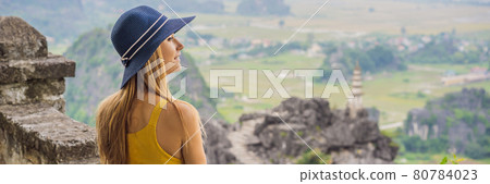 BANNER, LONG FORMAT Woman tourist on top pagoda of Hang Mua temple, rice fields, Ninh Binh, Vietnam. Vietnam reopens borders after quarantine Coronovirus COVID 19 BANNER, LONG FORMAT Woman tourist on top pagoda of Hang Mua temple, rice fields, Ninh Binh, Vietnam. Vietnam reopens borders after quarantine Coronovirus COVID 19 80784023
