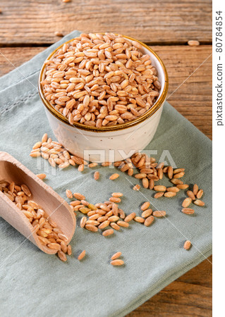 Wholegrain uncooked raw spelt farro in bowl on the wooden background Wholegrain uncooked raw spelt farro in bowl on the wooden background 80784854