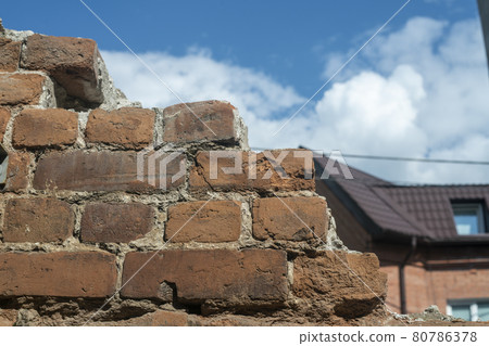 Old brown brick wall against the blue sky. 80786378
