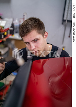Close shot of dent removing without paint, using rubber hammer Close shot of dent removing without paint, using rubber hammer 80786599