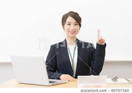 A young female teacher sitting in front of a whiteboard and smiling Photographing cooperation: Japanese language school attached to Chuo College of Technology 80787160