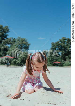 Little cute girl on beach. little girl playing in the sand. 80787690