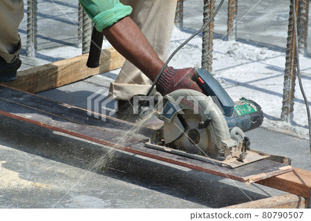 MALACCA, MALAYSIA -APRIL 25, 2016: Carpenter using electrical powered circular saw to cut plywood at the construction site in Malacca, Malaysia. MALACCA, MALAYSIA -APRIL 25, 2016: Carpenter using electrical powered circular saw to cut plywood at the construction site in Malacca, Malaysia. 80790507