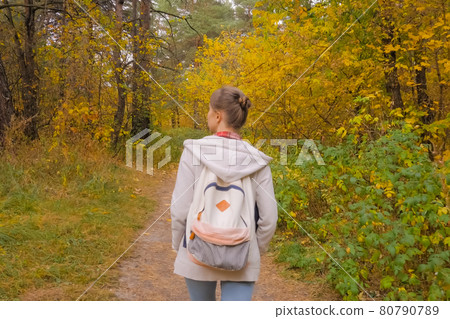 Back view of young woman with backpack walking in autumn park Back view of young woman with backpack walking in autumn park 80790789
