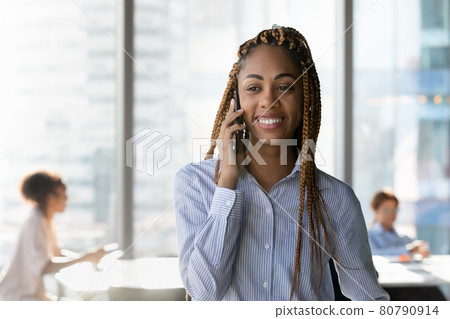 Smiling african ethnicity business lady holding cellphone conversation. Smiling african ethnicity business lady holding cellphone conversation. 80790914