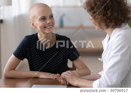 Smiling young cancer patient consulting with doctor. 80790917