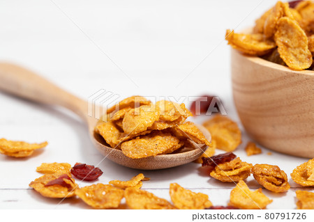 The wooden bowl of caramel cornflakes with raisins The wooden bowl of caramel cornflakes with raisins 80791726