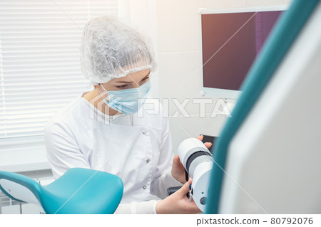 gynecologist prepares the colposcope before the patient arrives 80792076
