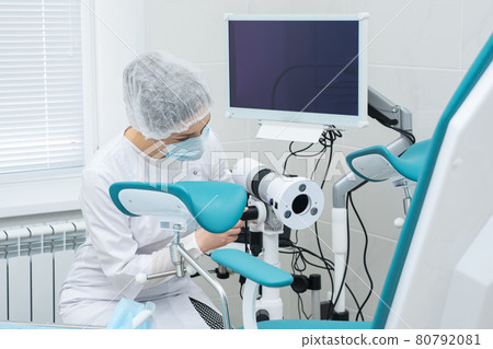 doctor prepares the colposcope before the patient arrives 80792081