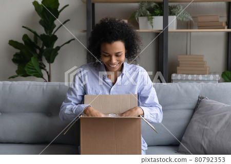 Excited biracial woman unpack box shopping on web 80792353