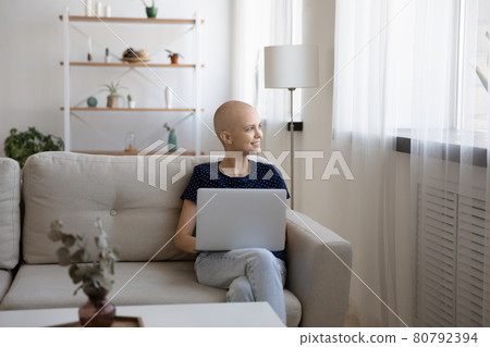 Dreamy young relaxed hairless sitting at home with computer. Dreamy young relaxed hairless sitting at home with computer. 80792394