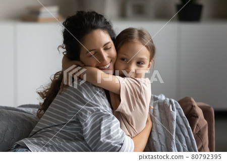 Happy excited mother embracing cute daughter kid with closed eyes Happy excited mother embracing cute daughter kid with closed eyes 80792395