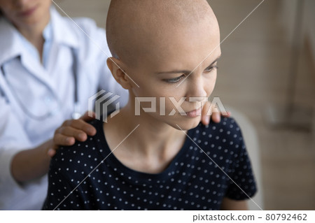 Depressed young female bald patient taking psychological support from doctor. Depressed young female bald patient taking psychological support from doctor. 80792462