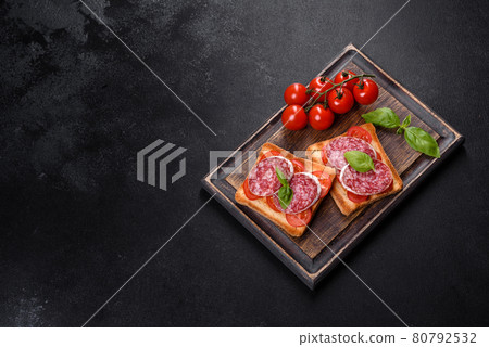 Spanish dried sausage salami on a dark concrete background Spanish dried sausage salami on a dark concrete background 80792532