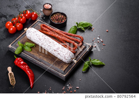 Spanish dried sausage salami on a dark concrete background Spanish dried sausage salami on a dark concrete background 80792564