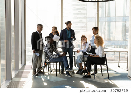 Young male african leader coaching diverse colleagues. 80792719