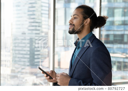 Young african businessman holding smartphone in hands. 80792727