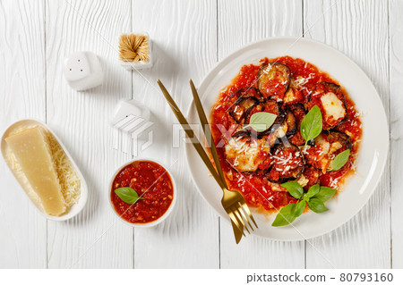 eggplant parmigiana on a white plate, top view 80793160