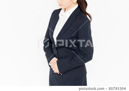 一位身著西裝的女商人站在白色背景前，把手放在肚子上 80793304