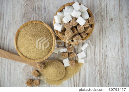 Brown sugar in a square cup and wooden spoon on a wooden table, healthy sugar is used for cooking food or desserts. Brown sugar in a square cup and wooden spoon on a wooden table, healthy sugar is used for cooking food or desserts. 80793457