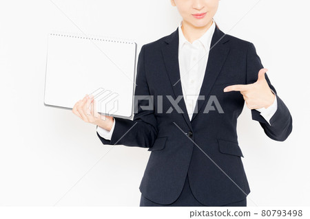 Businesswoman in a suit with a small sketchbook standing in front of a white background Businesswoman in a suit with a small sketchbook standing in front of a white background 80793498